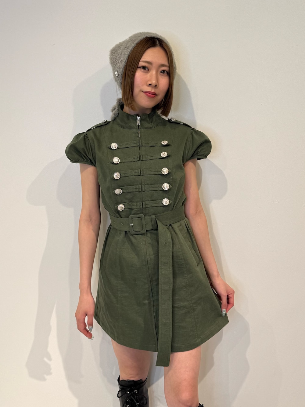 グリーン系のワンピース、ブラック系のブーツ、グレー系のその他ヘアアクセサリーを着用したレディースの春コーディネートの5枚目の写真