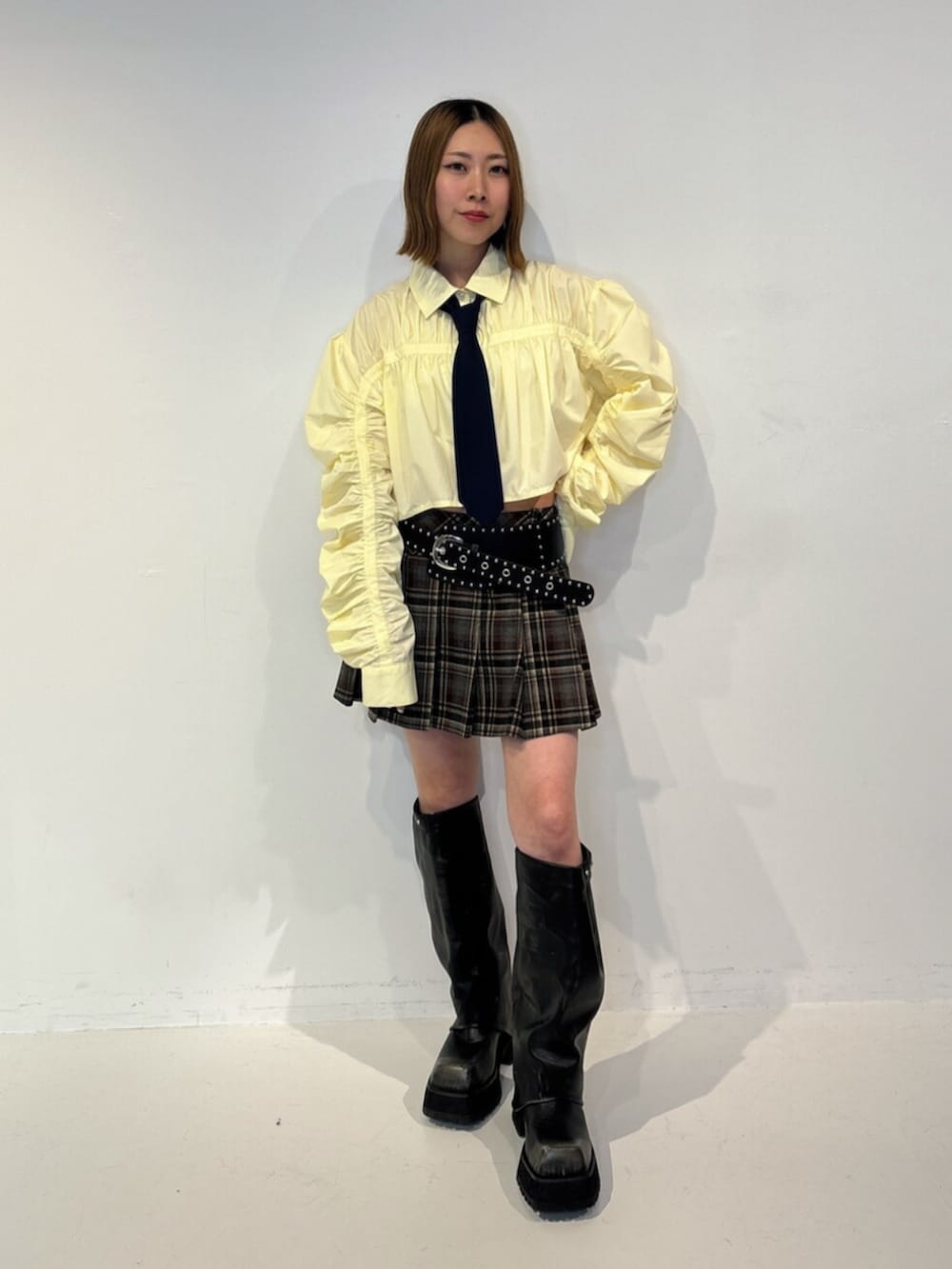ブラック系のブーツ、イエロー系のシャツ/ブラウス、レッド系のスカートを着用したレディースの夏コーディネートの2枚目の写真