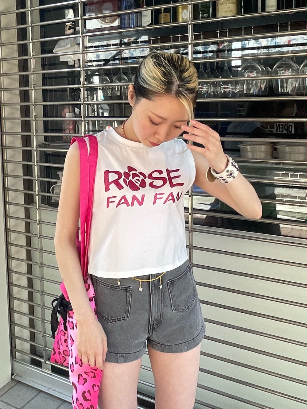 ホワイト系のタンクトップ、ブラック系のデニムパンツ、ピンク系のトートバッグを着用したレディースの春コーディネートの6枚目の写真