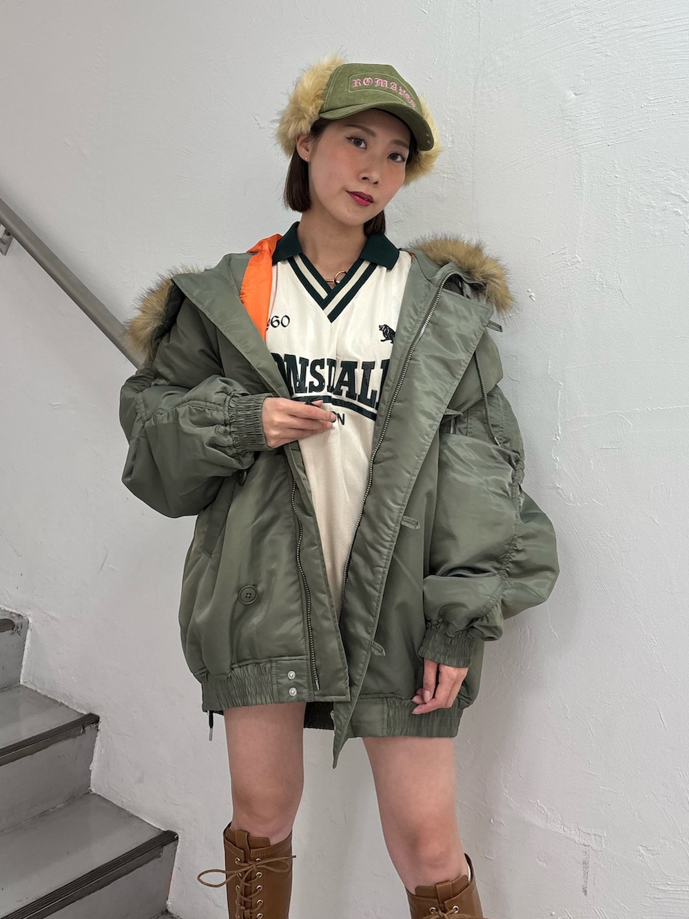 ホワイト系のTシャツ/カットソー、ホワイト系のスカート、グリーン系のブルゾンを着用したレディースの秋コーディネートの6枚目の写真