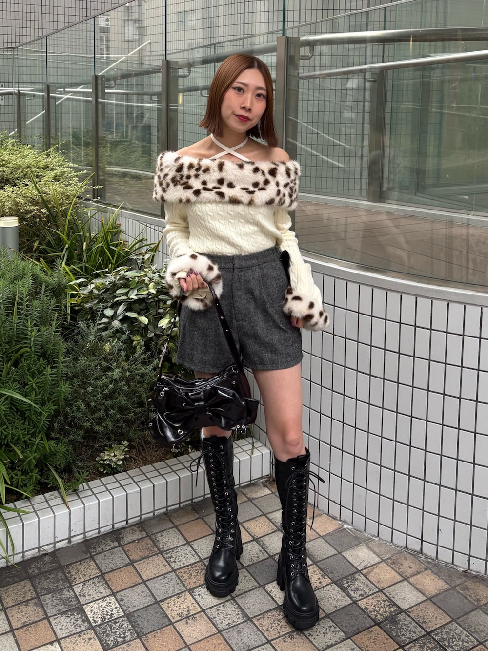 グレー系のその他パンツ、ホワイト系のニット/セーター、ブラック系のショルダーバッグを着用したレディースの秋コーディネートの2枚目の写真