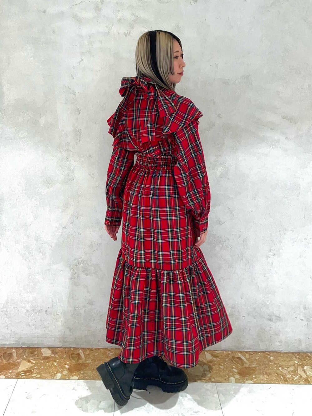 レッド系のワンピース、ゴールド系のネックレスを着用したレディースの冬コーディネートの2枚目の写真