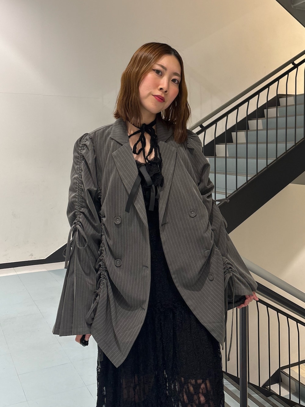 ブラック系のワンピース、グレー系のテーラードジャケット、ブラウン系のブーツを着用したレディースの冬コーディネートの5枚目の写真