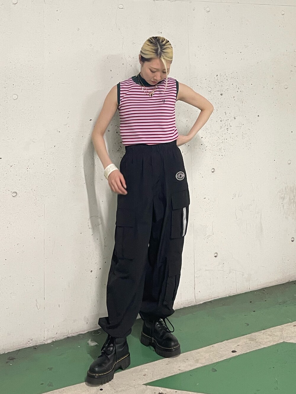 ブラック系のカーゴパンツ、ピンク系のニット/セーター、ホワイト系のブレスレットを着用したレディースの夏コーディネートの2枚目の写真