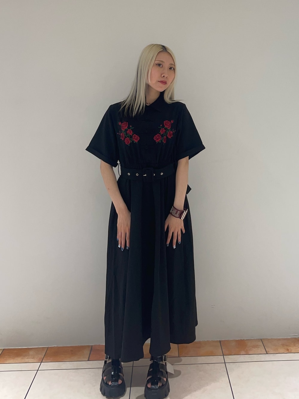 ブラック系のワンピース、ブラック系のサンダル、レッド系のブレスレットを着用したレディースの夏コーディネートの2枚目の写真