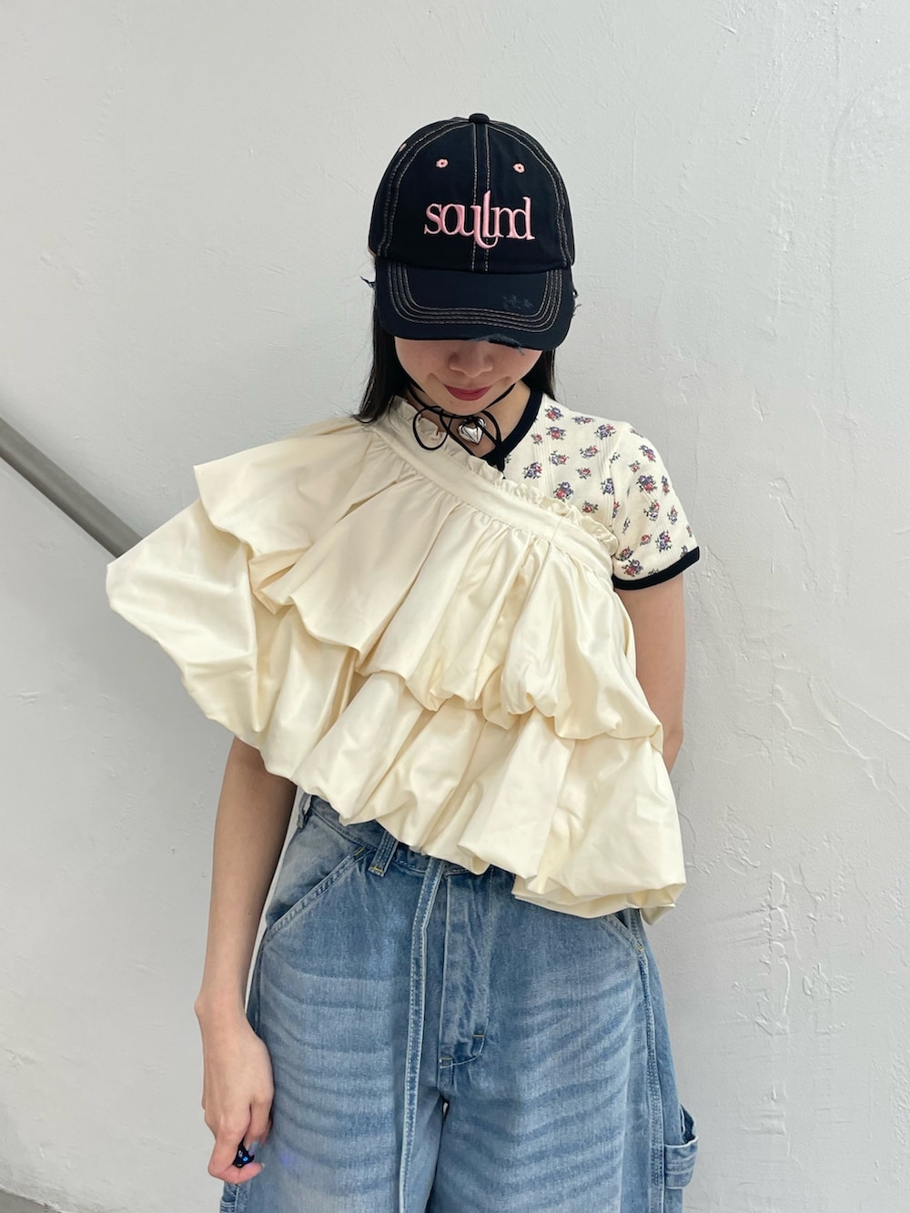 ブルー系のデニムパンツ、ホワイト系のスカート、ホワイト系のTシャツ/カットソーを着用したレディースの春コーディネートの6枚目の写真