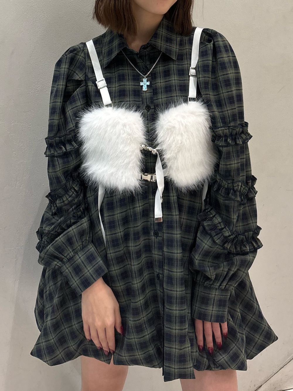 グリーン系のワンピース、ブラック系のブーツ、ホワイト系のベルトを着用したレディースの冬コーディネートの7枚目の写真