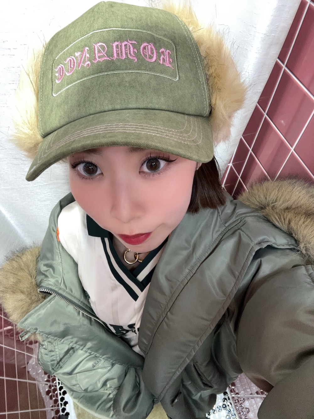 ホワイト系のTシャツ/カットソー、ホワイト系のスカート、グリーン系のブルゾンを着用したレディースの秋コーディネートの10枚目の写真