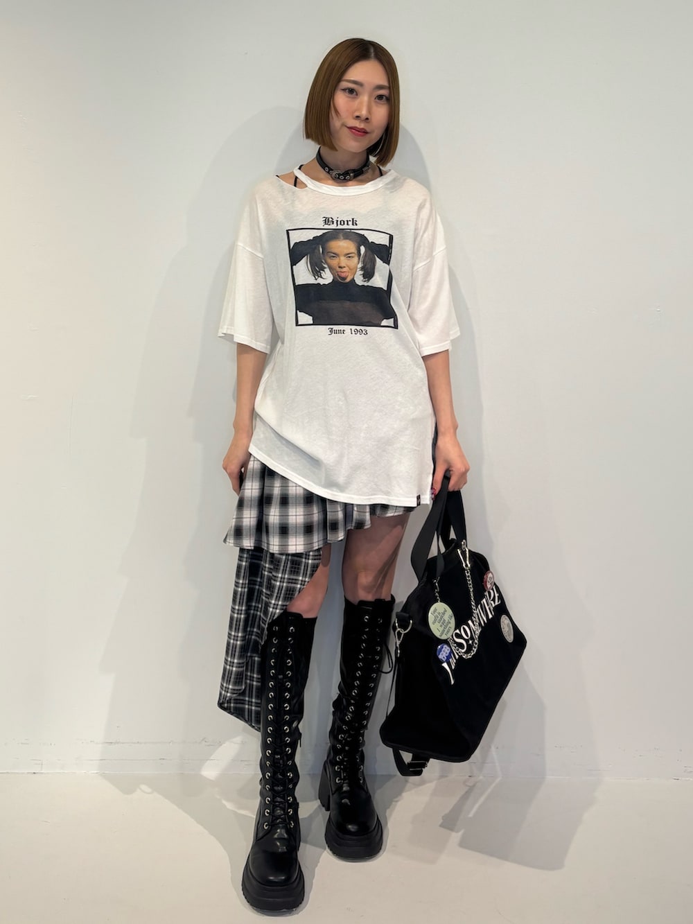 ブラック系のブーツ、ブラック系のボストンバッグ、ブラック系のスカートを着用したレディースの冬コーディネートの2枚目の写真