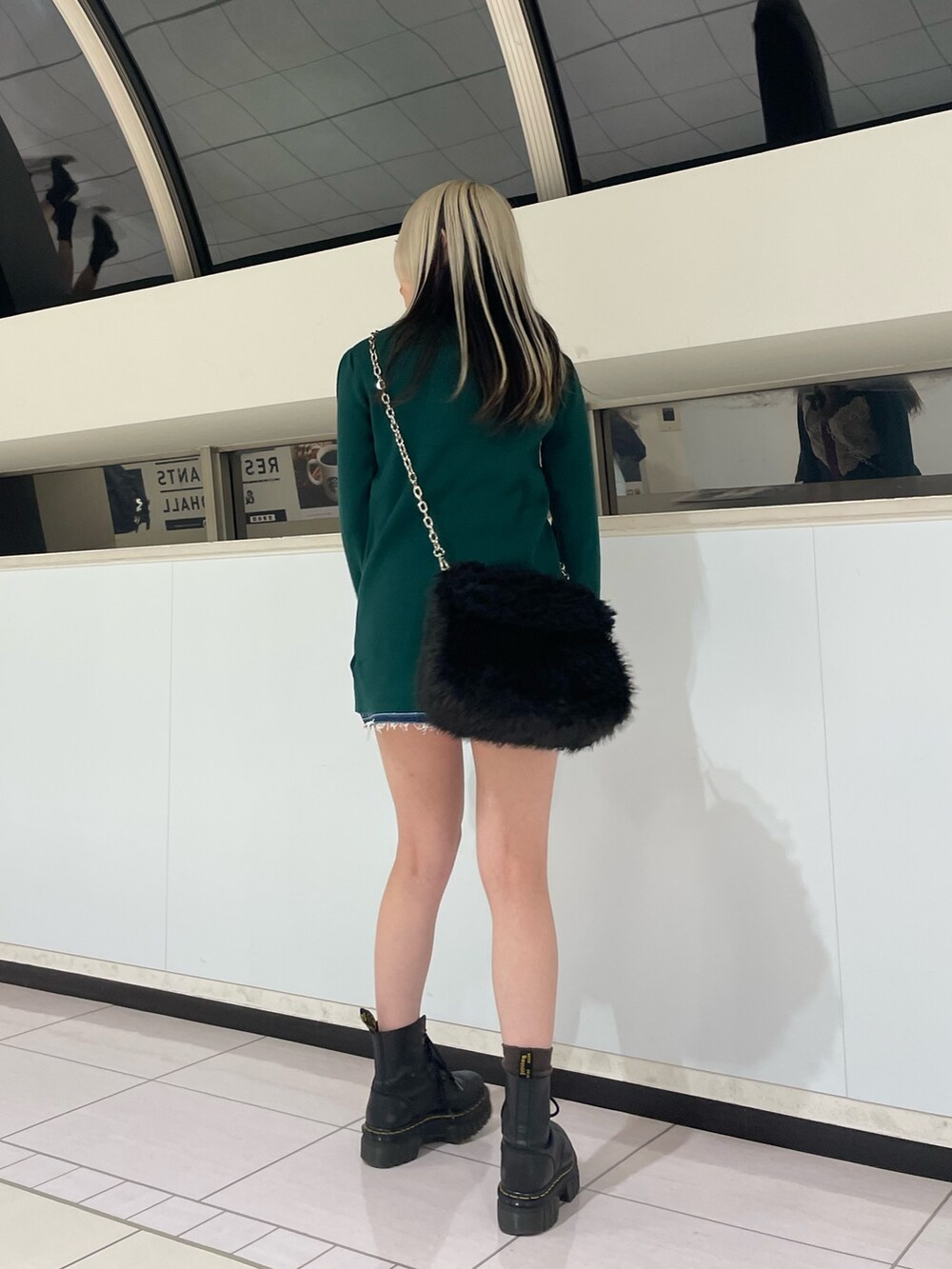 グリーン系のカーディガン/ボレロ、ブルー系のデニムパンツ、ブラック系のハンドバッグを着用したレディースの冬コーディネートの3枚目の写真