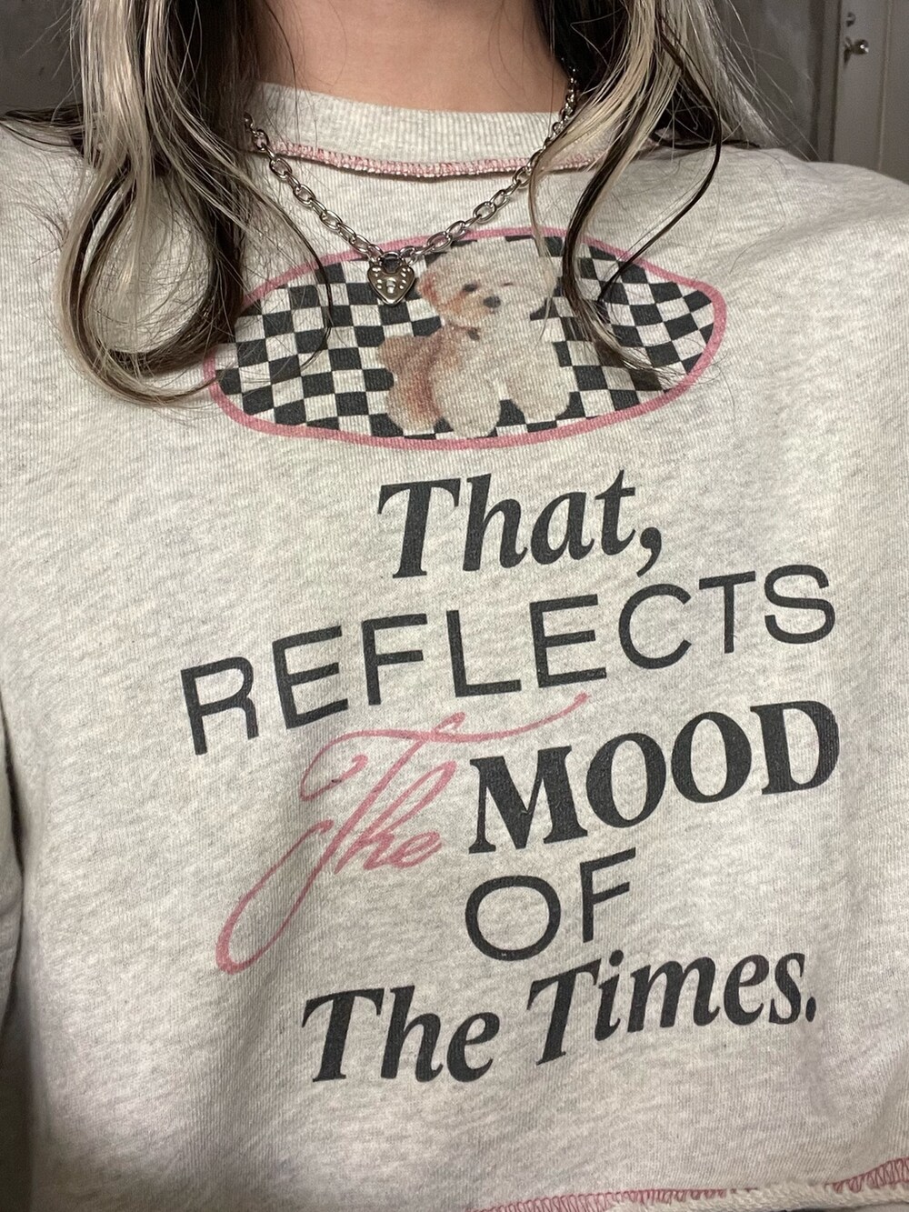 グレー系のスウェット、ブルー系のジャンパースカート、ブラック系のブーツを着用したレディースの冬コーディネートの7枚目の写真