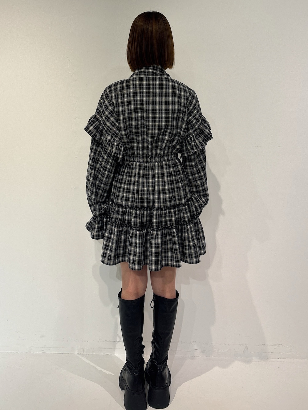 ブラック系のワンピース、ブラック系のトートバッグ、ブラック系のブーツを着用したレディースの冬コーディネートの4枚目の写真