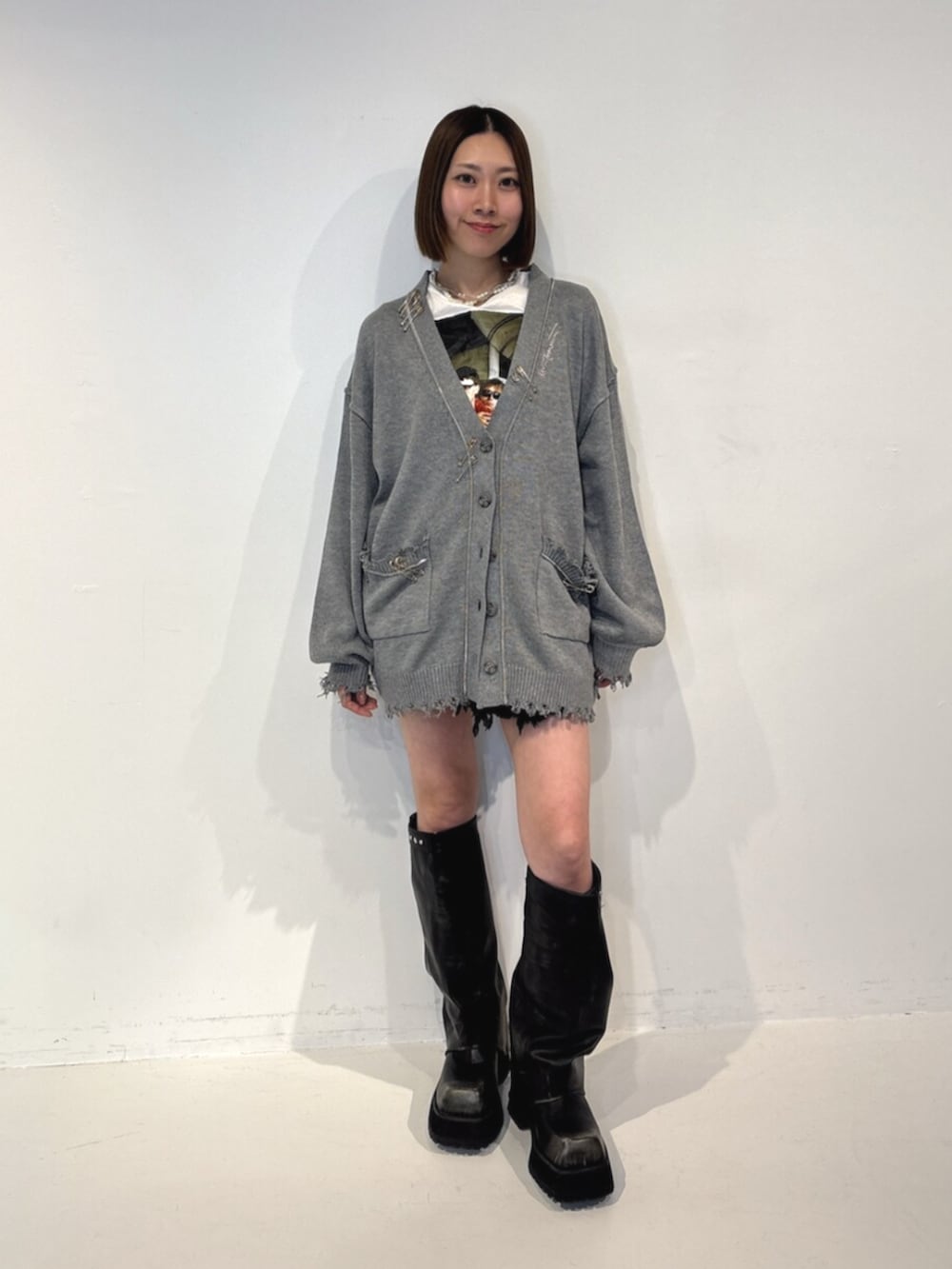 ブラック系のブーツ、グレー系のカーディガン/ボレロ、ホワイト系のTシャツ/カットソーを着用したレディースの夏コーディネートの2枚目の写真