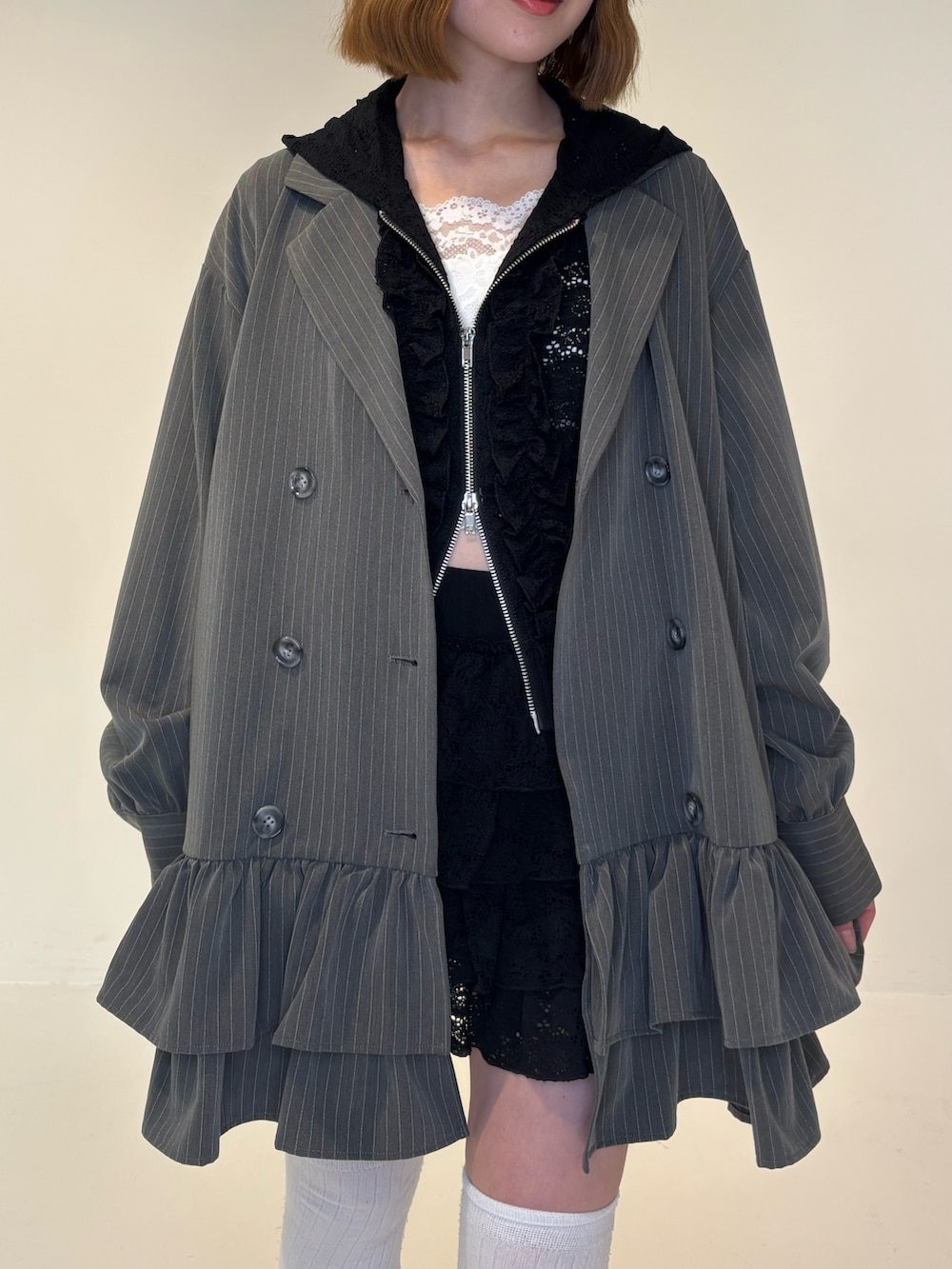 グレー系のワンピース、ブラック系のスカート、ブラック系のパーカーを着用したレディースの春コーディネートの6枚目の写真