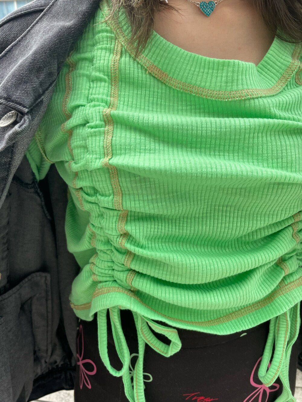 ブラック系のスカート、グリーン系のTシャツ/カットソー、ブラック系のデニムジャケットを着用したレディースの春コーディネートの9枚目の写真