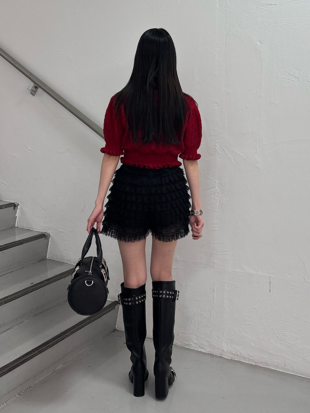 ブラック系のブーツ、ブラック系のボストンバッグ、ブラック系のその他パンツを着用したレディースの春コーディネートの5枚目の写真