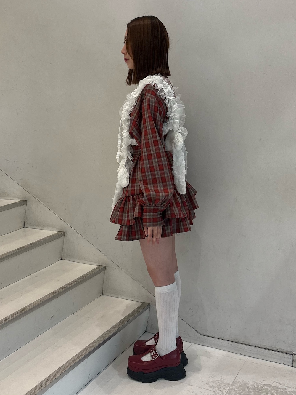 レッド系のワンピース、レッド系のローファー、ホワイト系のベルトを着用したレディースの冬コーディネートの3枚目の写真