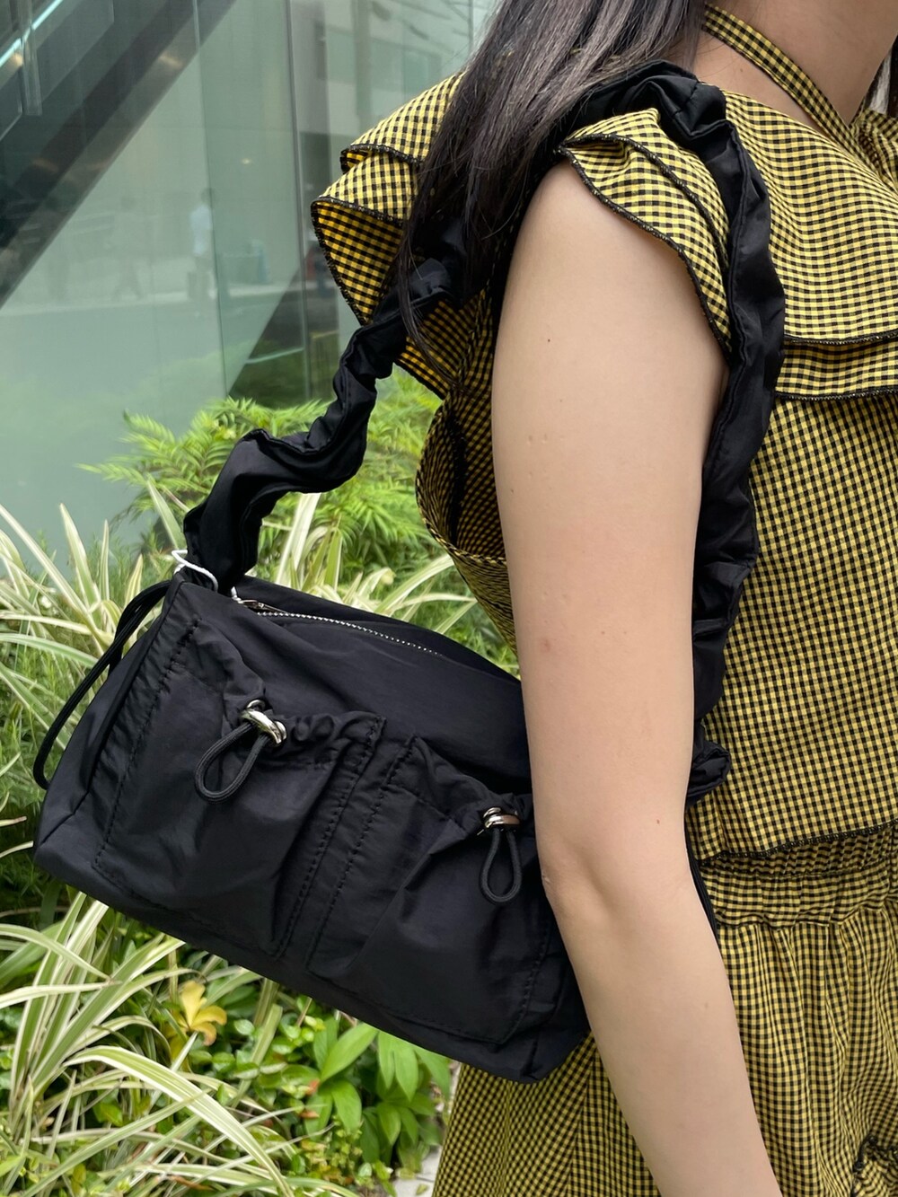 イエロー系のスカート、イエロー系のシャツ/ブラウス、ブラック系のショルダーバッグを着用したレディースの夏コーディネートの7枚目の写真