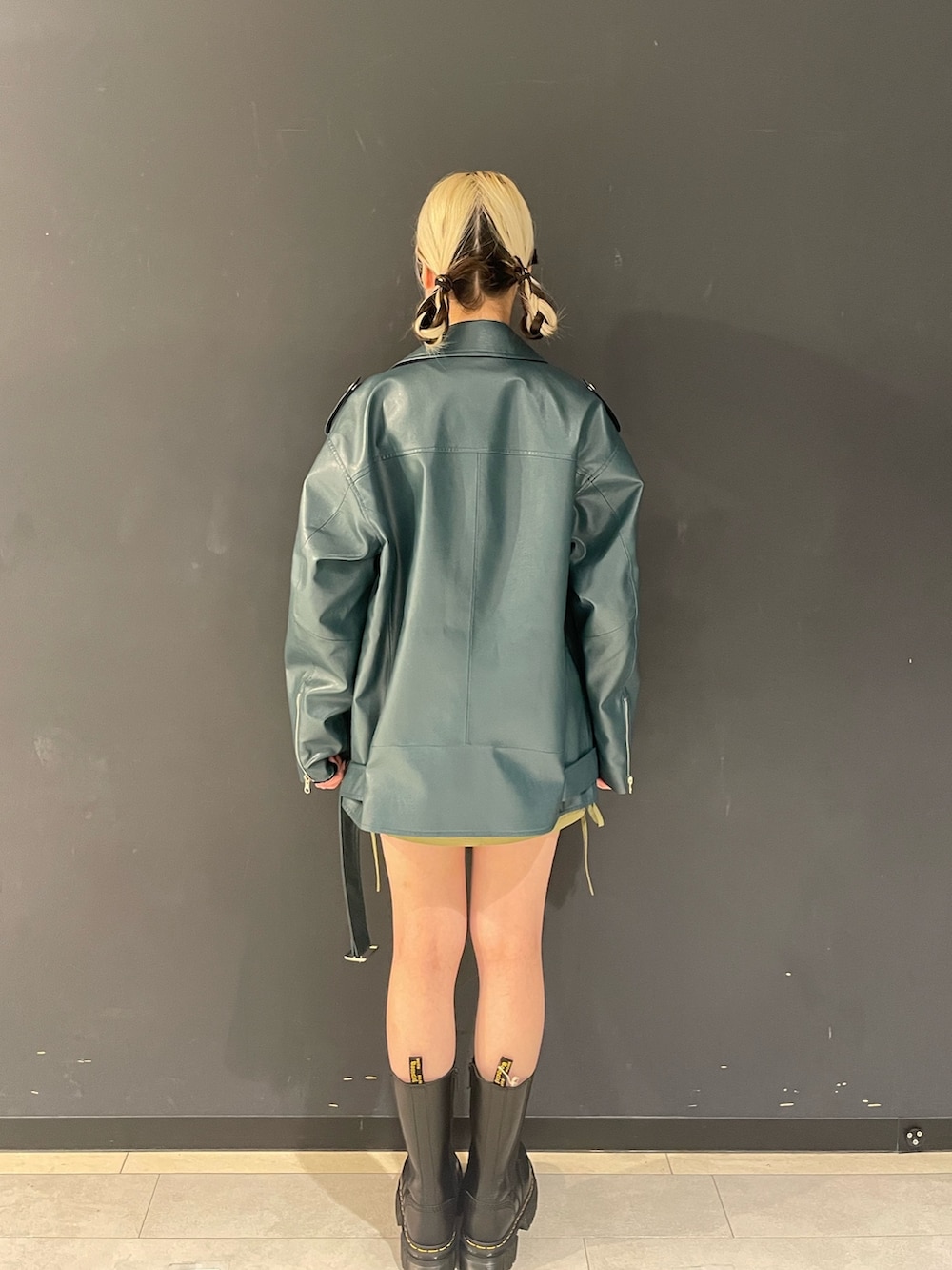 ホワイト系のTシャツ/カットソー、グリーン系のスカート、ブルー系のライダースジャケットを着用したレディースの秋コーディネートの3枚目の写真