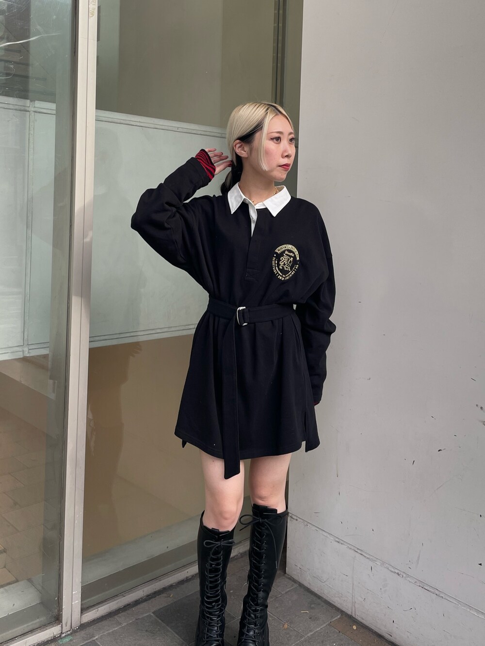 ブラック系のシャツワンピース、レッド系のダウンベスト、ブラック系のブーツを着用したレディースの秋コーディネートの8枚目の写真