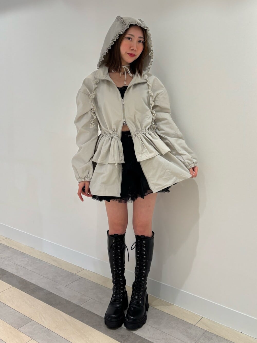 ブラウン系のブーツ、レッド系のスカート、ホワイト系のナイロンジャケットを着用したレディースの冬コーディネートの2枚目の写真