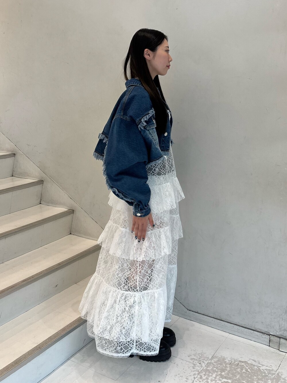 ホワイト系のワンピース、ブルー系のデニムジャケット、ブラック系のTシャツ/カットソーを着用したレディースの春コーディネートの4枚目の写真