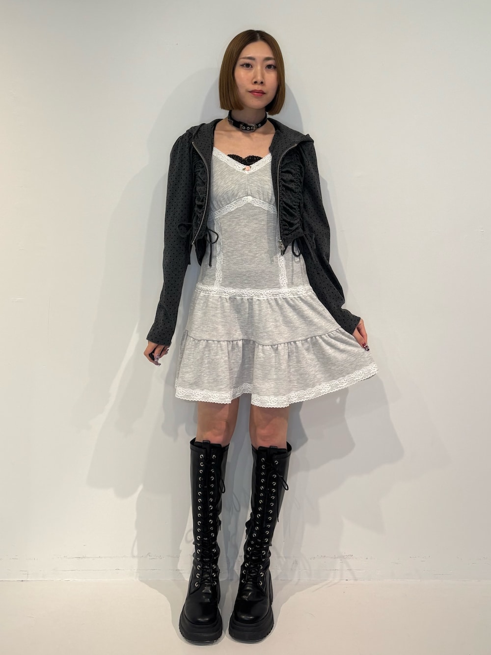 ブラック系のパーカー、グレー系のワンピース、ブラック系のブーツを着用したレディースの冬コーディネートの2枚目の写真