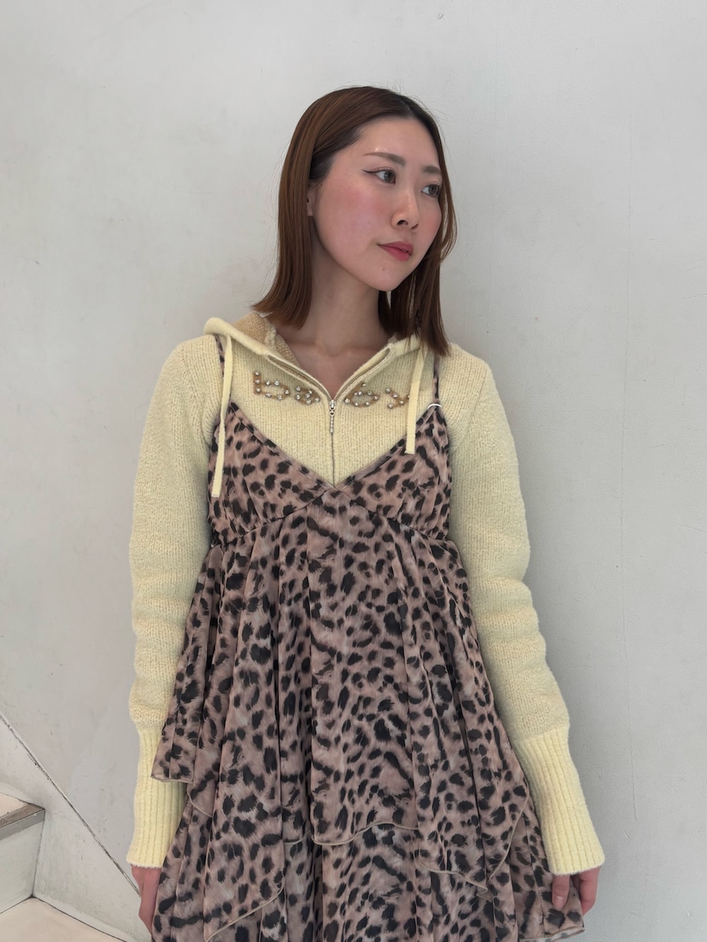 ブラウン系のワンピース、イエロー系のパーカー、ブラック系のブーツを着用したレディースの冬コーディネートの6枚目の写真