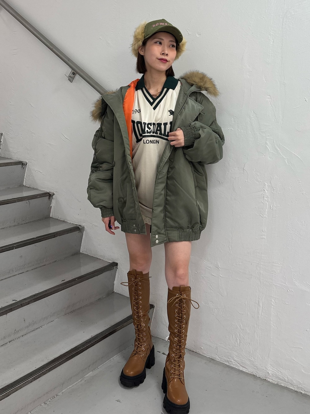 ホワイト系のTシャツ/カットソー、ホワイト系のスカート、グリーン系のブルゾンを着用したレディースの秋コーディネートの2枚目の写真