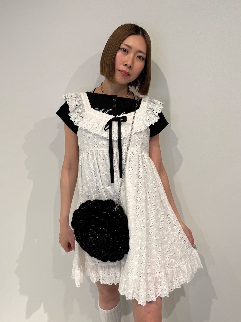 ホワイト系のワンピース、ブラック系のショルダーバッグ、ブラック系のTシャツ/カットソーを着用したレディースの春コーディネートの5枚目の写真