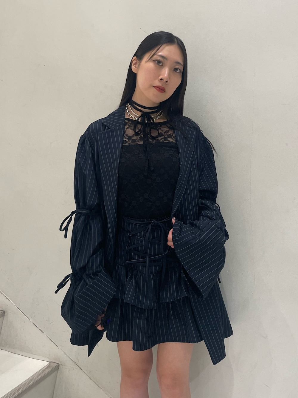 ブラック系のTシャツ/カットソー、ブルー系のテーラードジャケット、ブルー系のスカートを着用したレディースの秋コーディネートの6枚目の写真