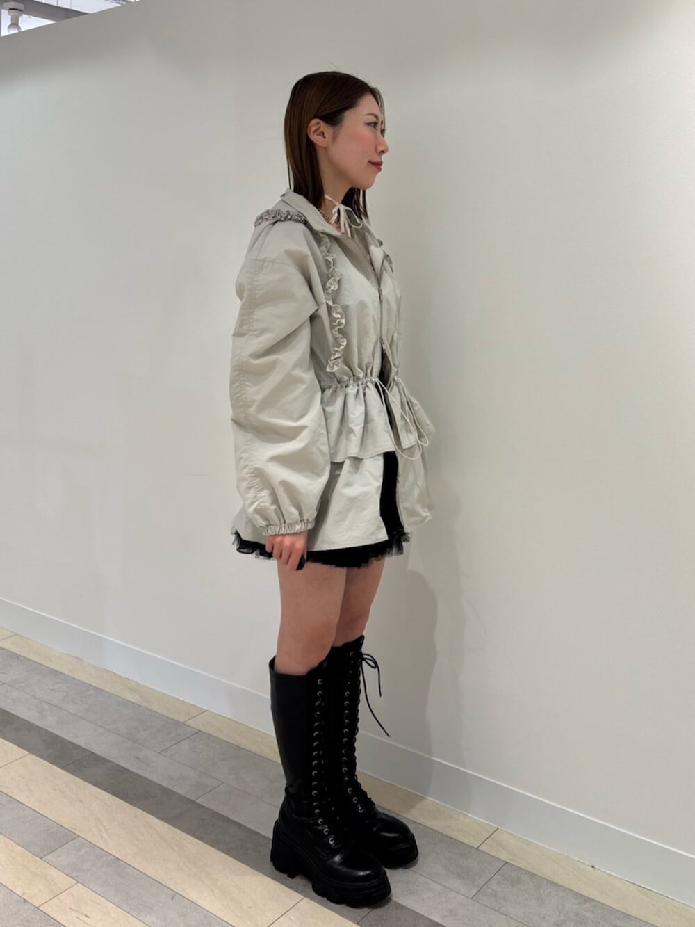 ブラウン系のブーツ、レッド系のスカート、ホワイト系のナイロンジャケットを着用したレディースの冬コーディネートの4枚目の写真