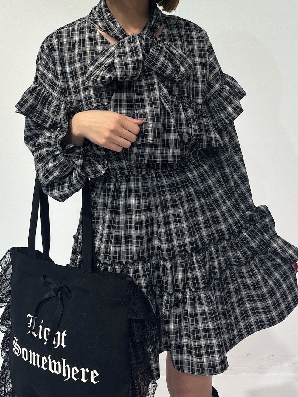 ブラック系のワンピース、ブラック系のトートバッグ、ブラック系のブーツを着用したレディースの冬コーディネートの7枚目の写真