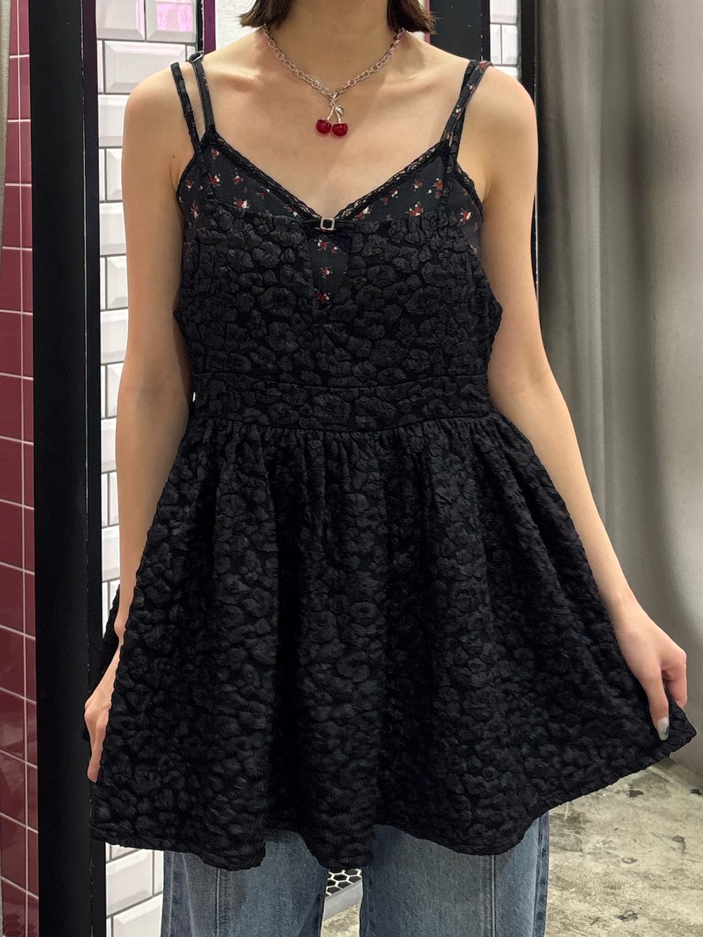 ブルー系のデニムパンツ、ブラック系のチュニック、レッド系のネックレスを着用したレディースの夏コーディネートの7枚目の写真