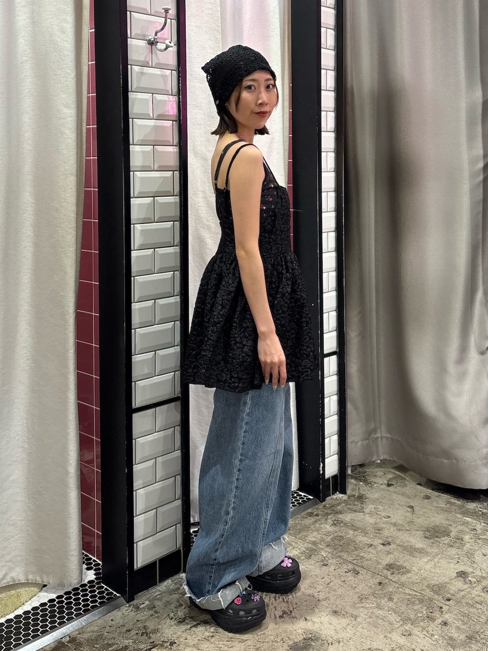 ブルー系のデニムパンツ、ブラック系のチュニック、レッド系のネックレスを着用したレディースの夏コーディネートの3枚目の写真