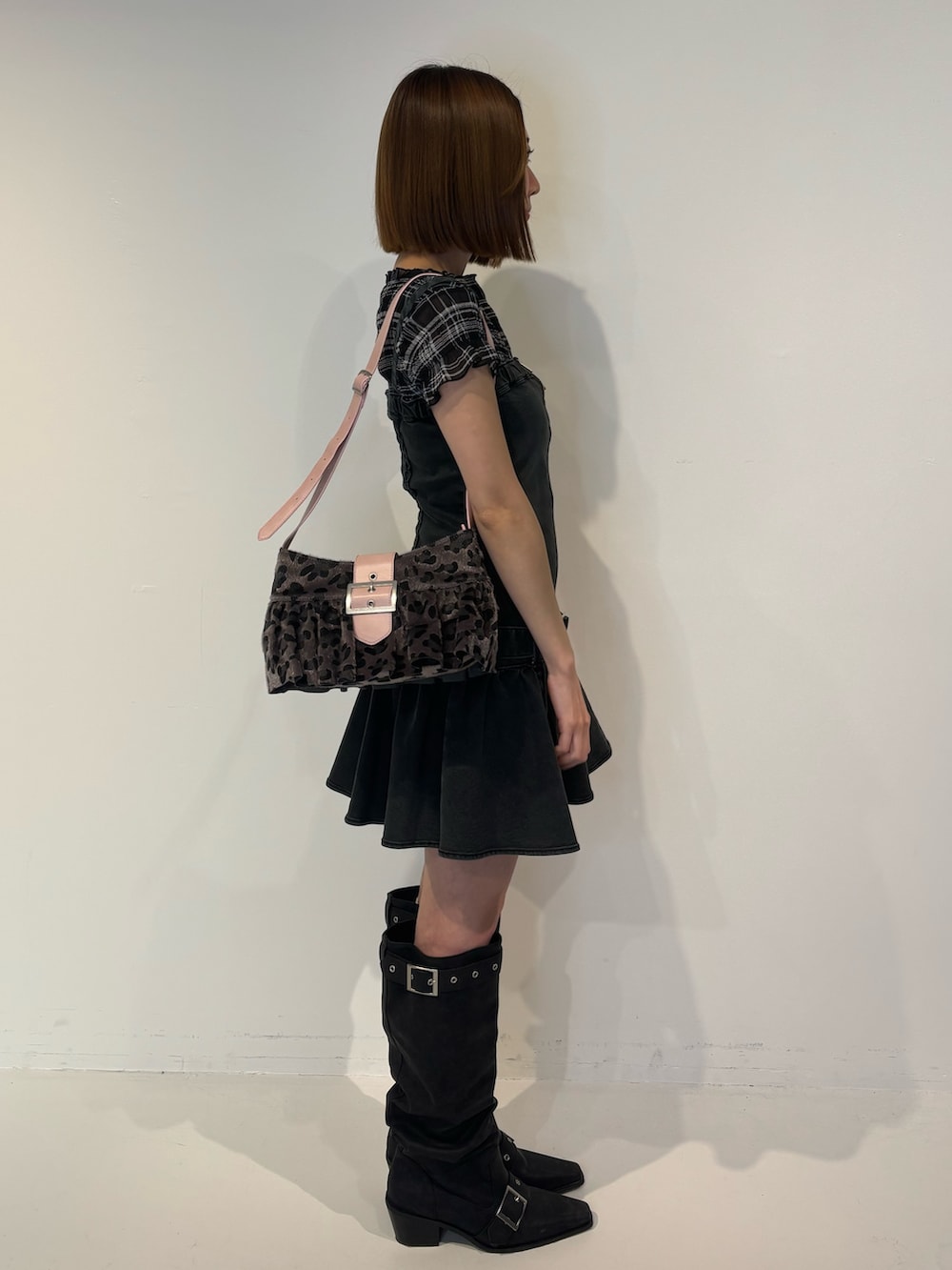 ブラック系のブーツ、ブラック系のワンピース、ブラック系のTシャツ/カットソーを着用したレディースの春コーディネートの3枚目の写真