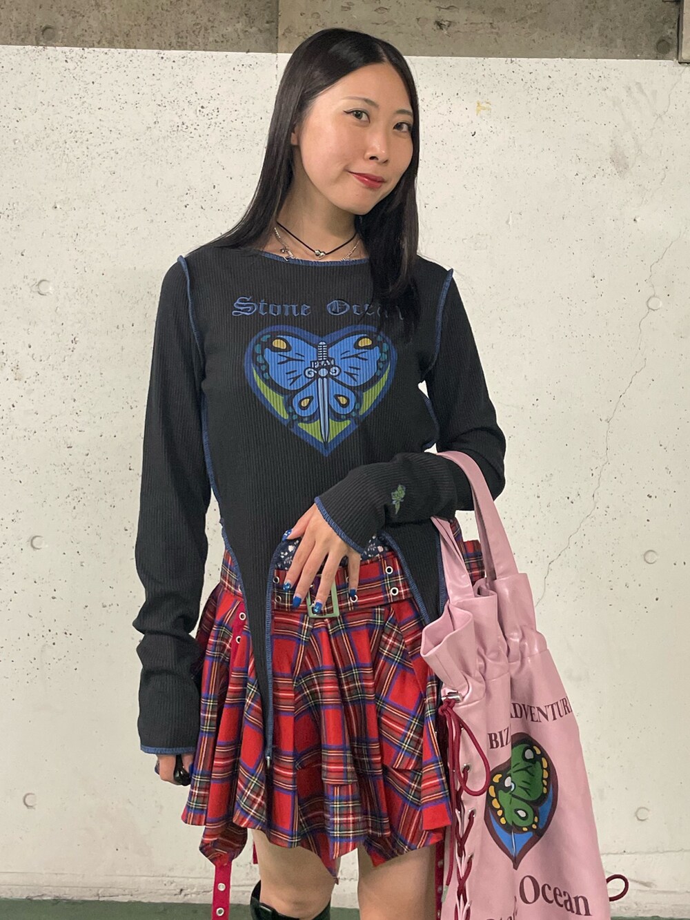 レッド系のスカート、ブラック系のブーツ、ブラック系のTシャツ/カットソーを着用したレディースの秋コーディネートの7枚目の写真