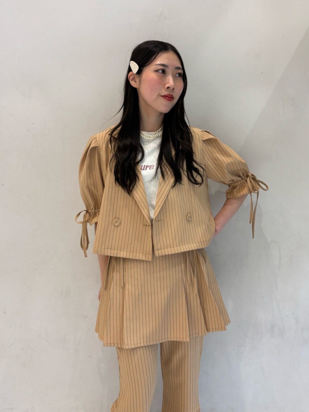 ベージュ系のテーラードジャケット、ベージュ系のその他パンツ、ベージュ系のスカートを着用したレディースの冬コーディネートの5枚目の写真