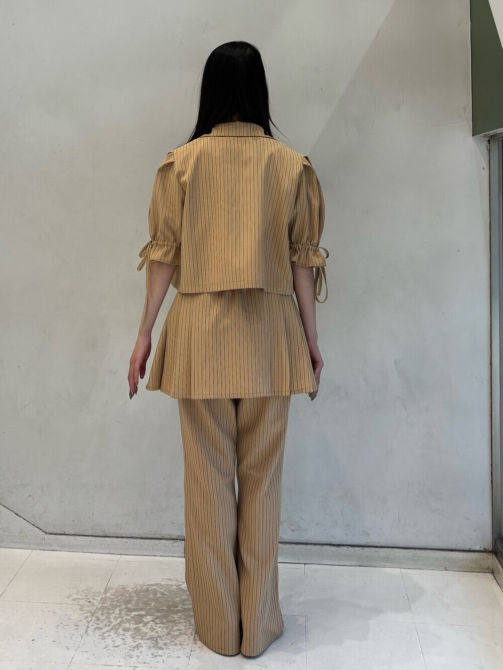 ベージュ系のテーラードジャケット、ベージュ系のその他パンツ、ベージュ系のスカートを着用したレディースの冬コーディネートの4枚目の写真