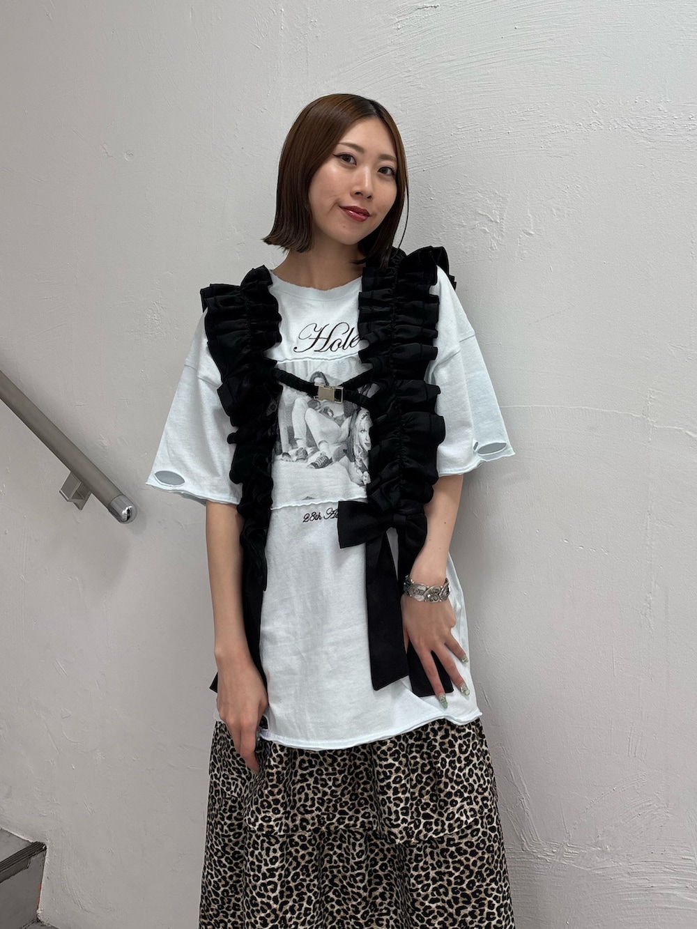 ブラウン系のスカート、ブルー系のTシャツ/カットソー、ブラック系のスニーカーを着用したレディースの夏コーディネートの6枚目の写真