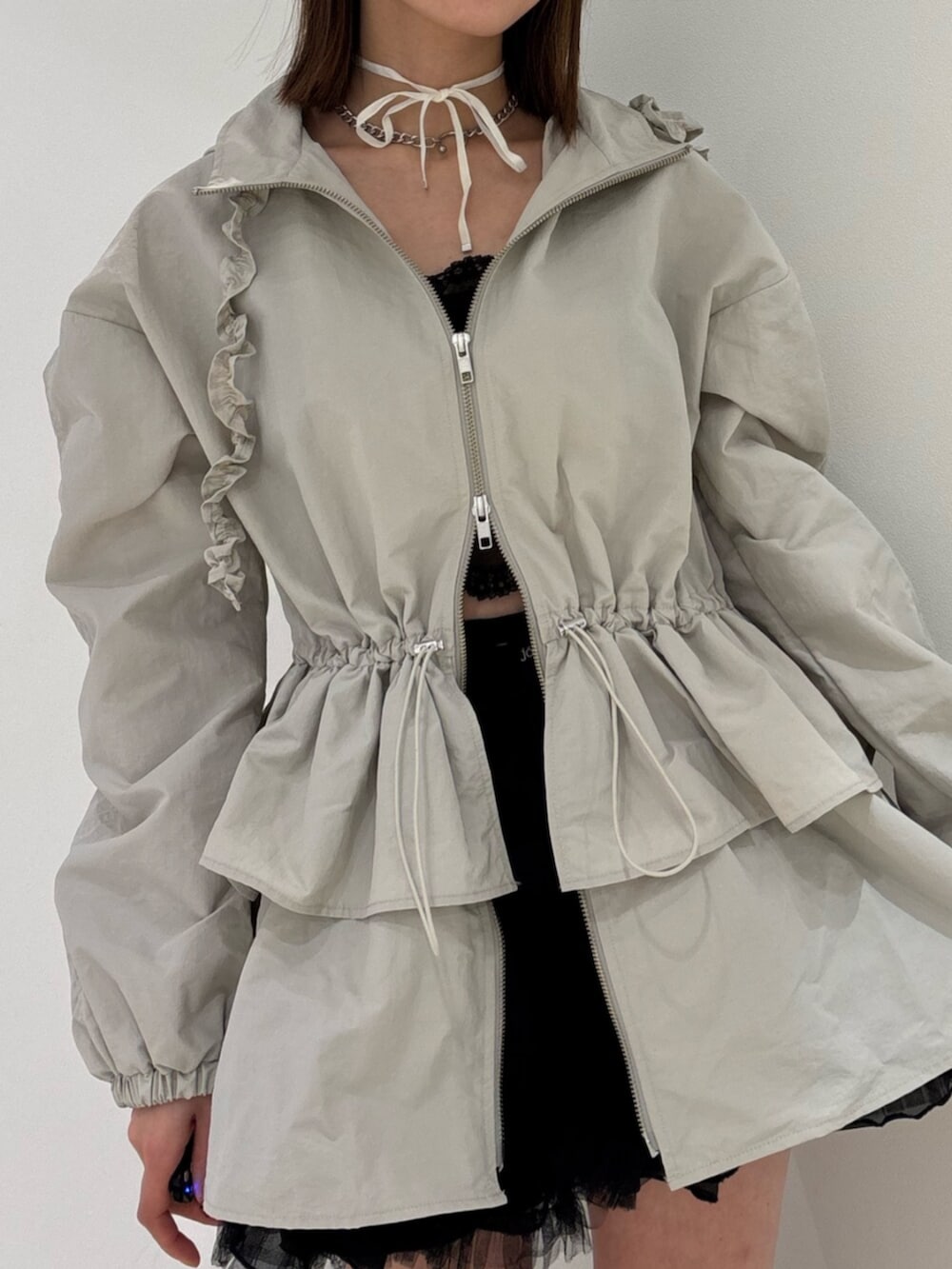 ブラウン系のブーツ、レッド系のスカート、ホワイト系のナイロンジャケットを着用したレディースの冬コーディネートの8枚目の写真