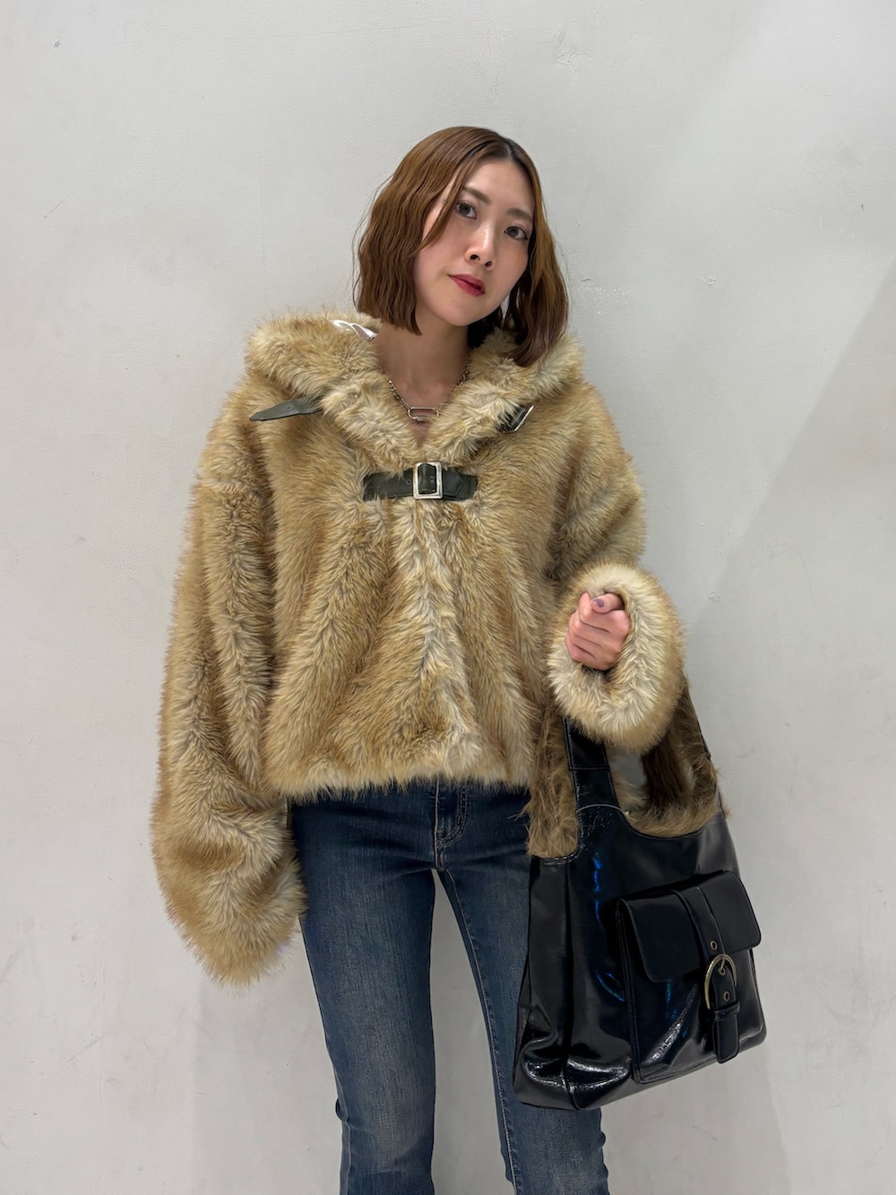 ブルー系のデニムパンツ、ブラック系のハンドバッグ、ブラック系のパンプスを着用したレディースの秋コーディネートの7枚目の写真