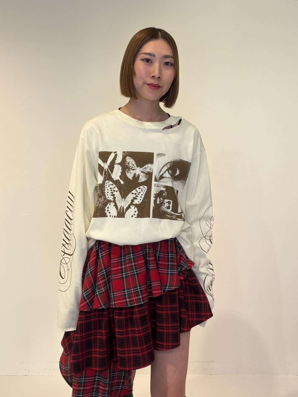 ブラック系のブーツ、ホワイト系のTシャツ/カットソー、レッド系のスカートを着用したレディースの冬コーディネートの5枚目の写真