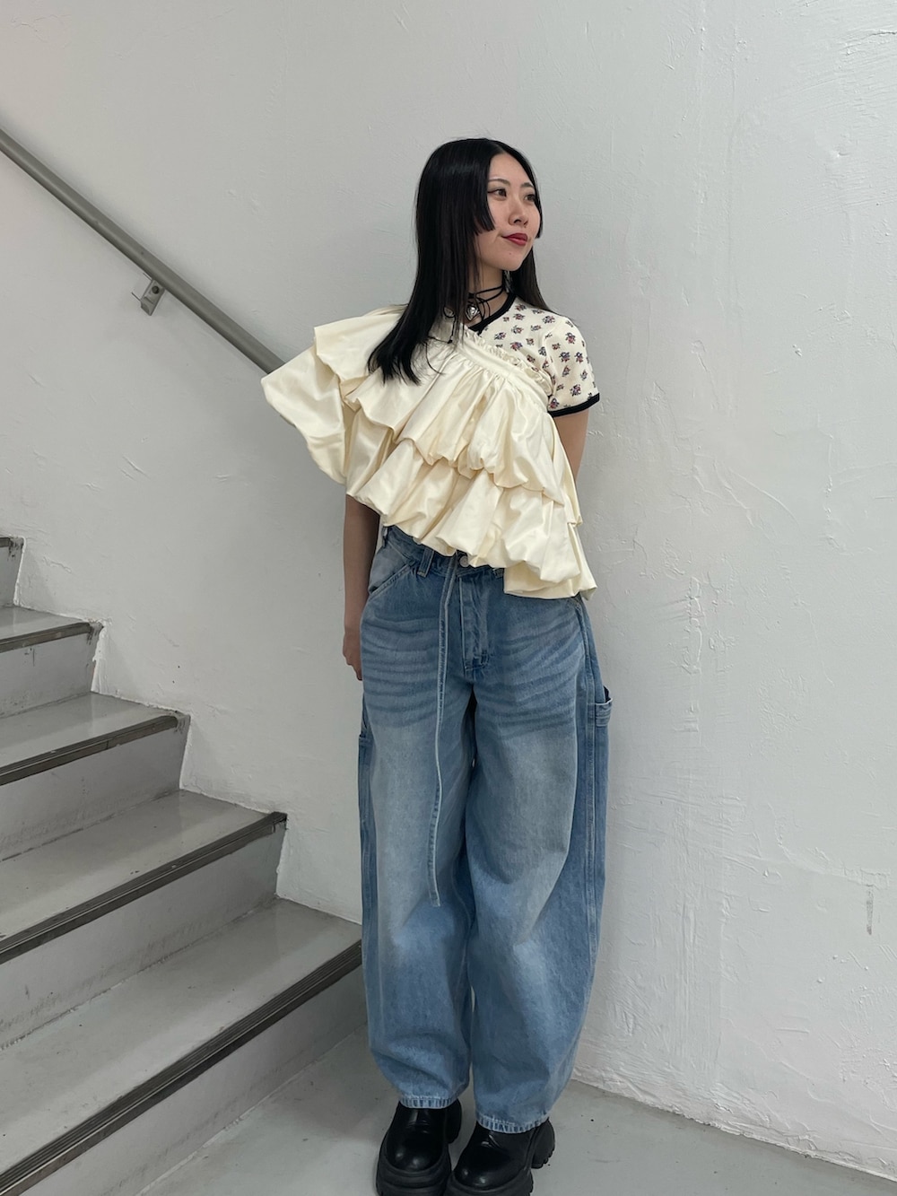ブルー系のデニムパンツ、ホワイト系のスカート、ホワイト系のTシャツ/カットソーを着用したレディースの春コーディネートの4枚目の写真