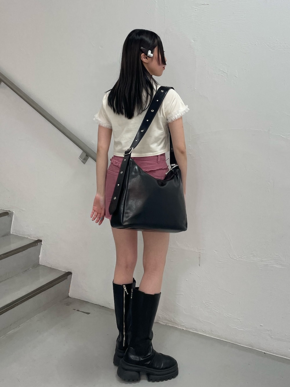 ピンク系のスカート、ホワイト系のTシャツ/カットソー、ブラック系のショルダーバッグを着用したレディースの春コーディネートの4枚目の写真