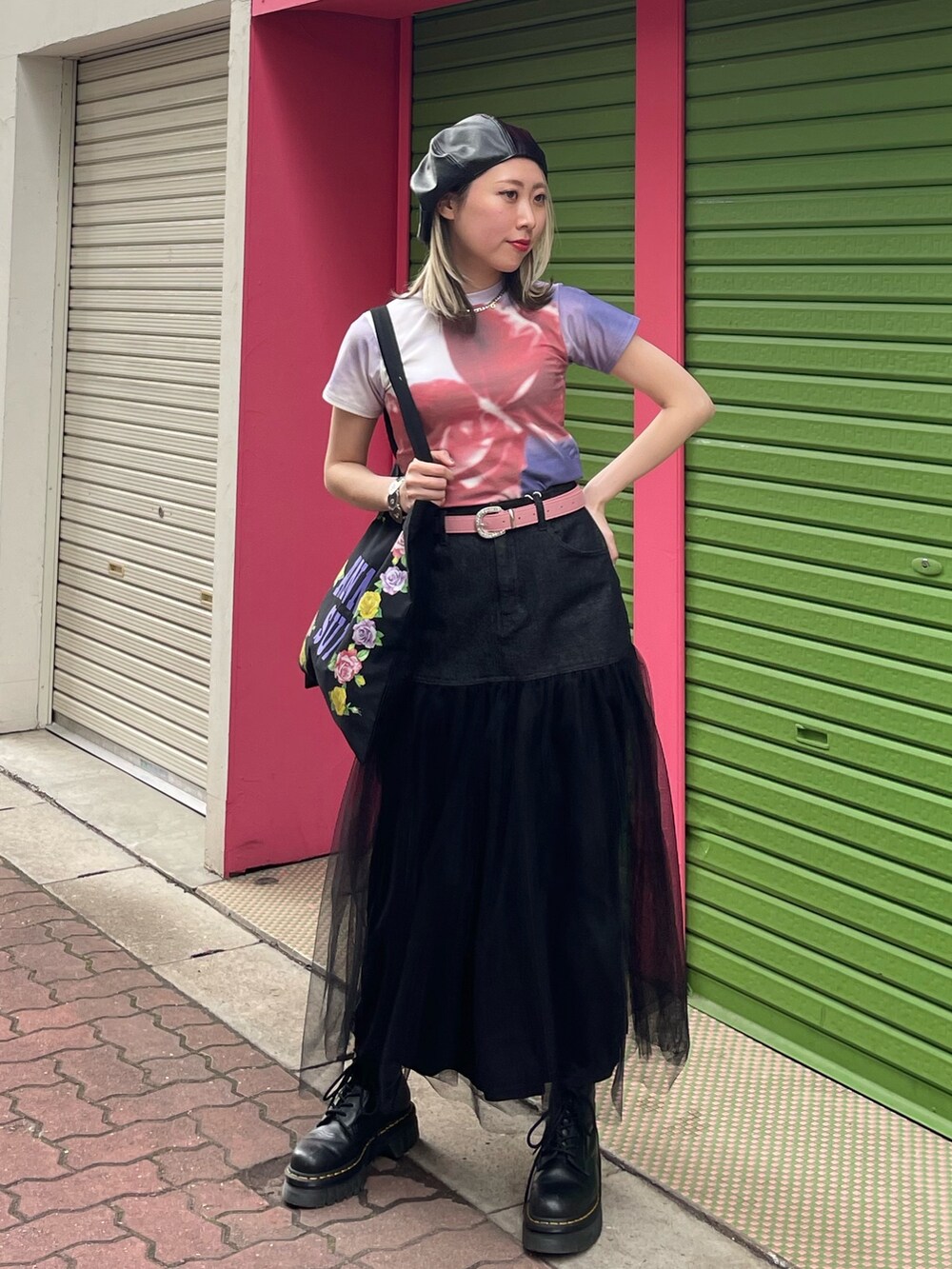 ブラック系のスカート、ブラック系のトートバッグ、パープル系のTシャツ/カットソーを着用したレディースの春コーディネートの2枚目の写真