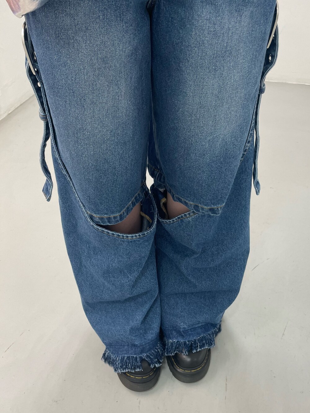 ブルー系のデニムパンツ、ブラック系のカーディガン/ボレロ、シルバー系のハンドバッグを着用したレディースの秋コーディネートの9枚目の写真