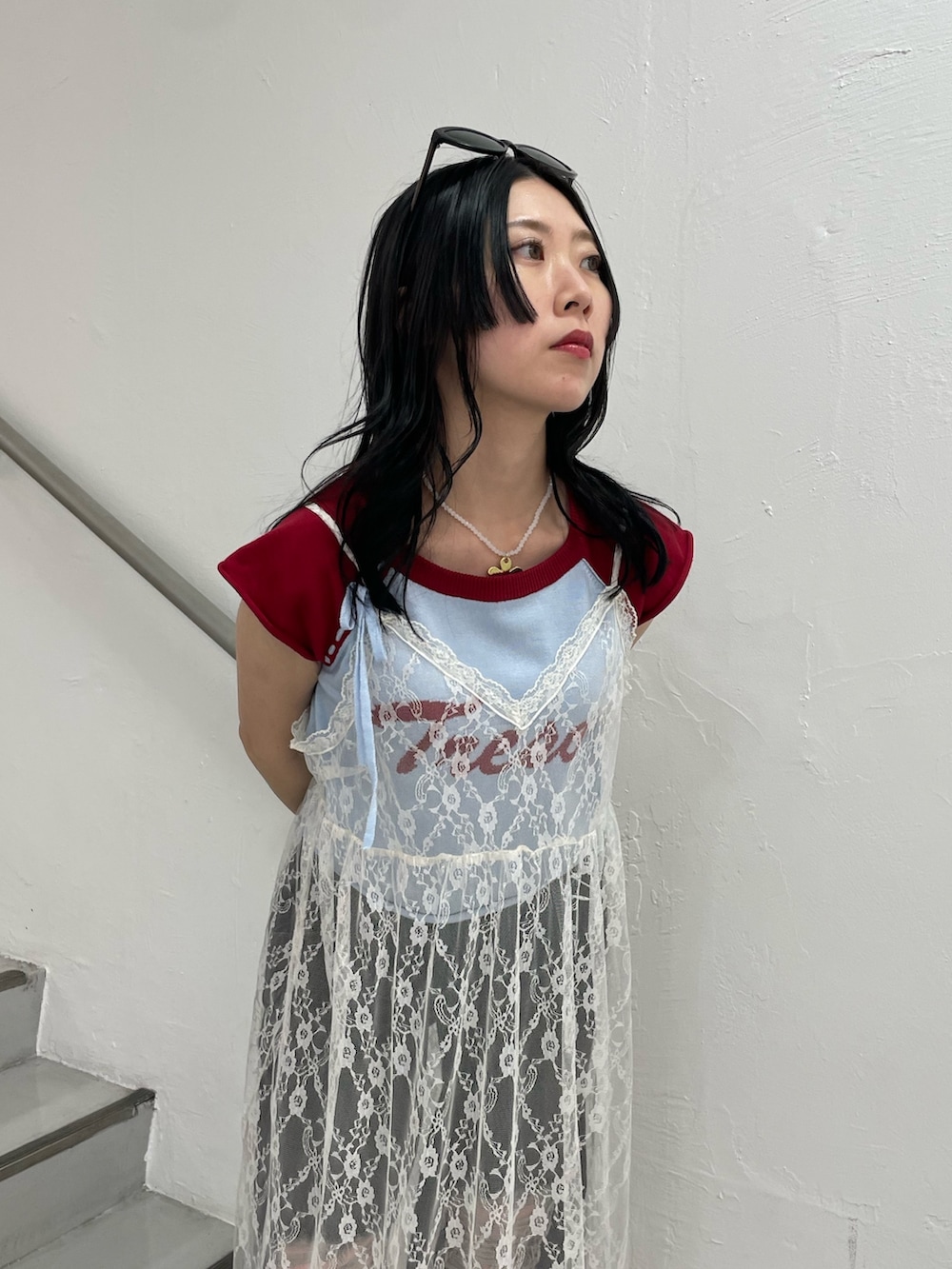 ブルー系のニット/セーター、ホワイト系のワンピース、ブラック系のデニムパンツを着用したレディースの春コーディネートの3枚目の写真