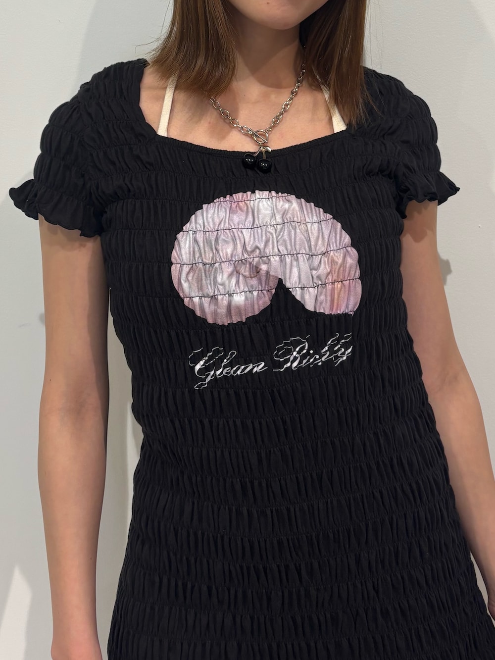 ブラック系のワンピース、ブラック系のブーツ、ホワイト系のキャミソールを着用したレディースの冬コーディネートの6枚目の写真