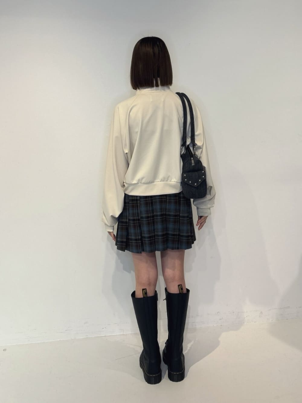 ブラック系のボストンバッグ、ホワイト系のTシャツ/カットソー、ブルー系のスカートを着用したレディースの夏コーディネートの4枚目の写真